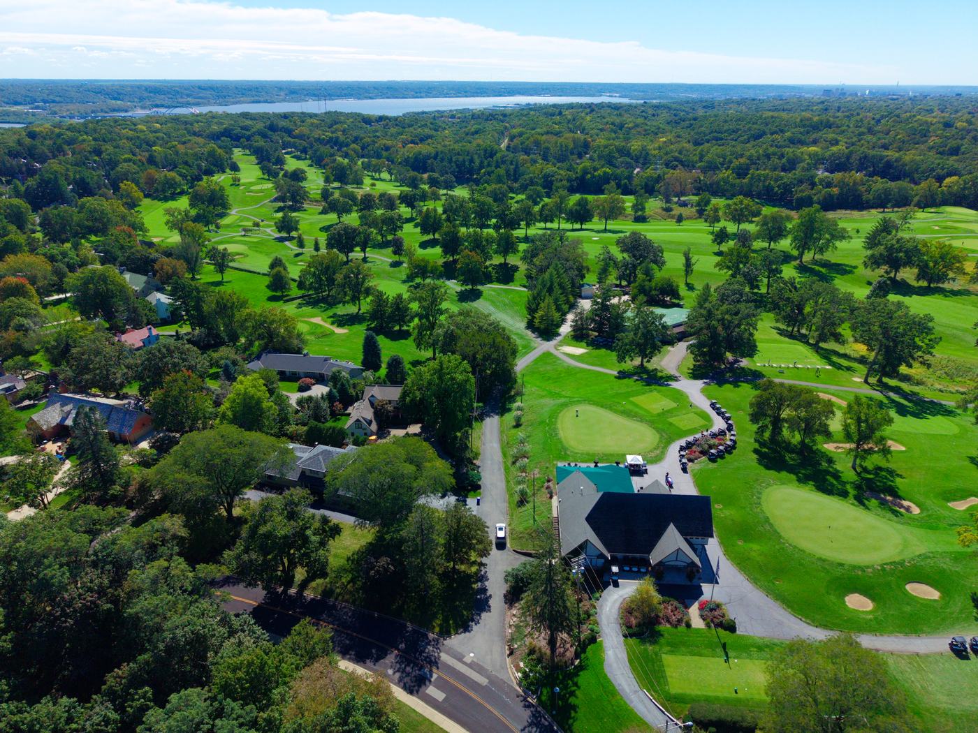 Aerial view of a Peoria golf clubhouse and fairways with the Illinois River in the distance