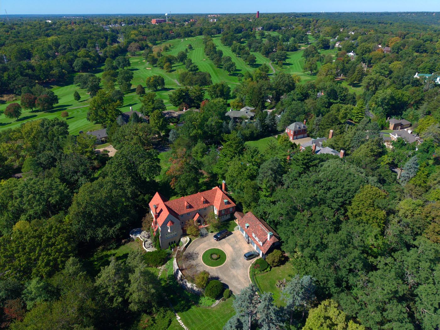 Drone view of a red-roof estate with a golf course stretching out behind it in Peoria